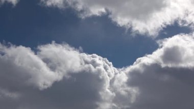  Hafif ve kabarık kış bulutları zıt aydınlık gökyüzünde hareket eder..