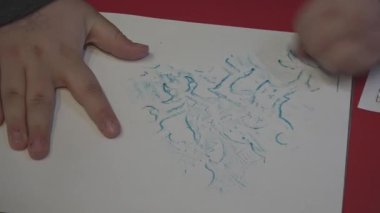 Childs 'ın elleri bir ejderhayı pastel boyayla ovuyor..