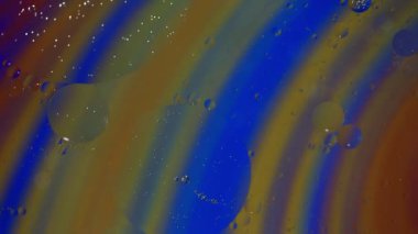 Yağ ve su kabarcıkları çok renkli girdap deseni üzerinde saat yönünde yavaş hareket eder.