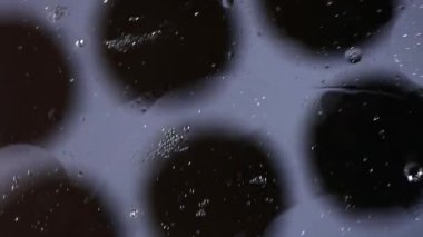 Yağ ve su kabarcıkları siyah noktalar üzerindeki şekiller gibi amiplerde yavaşça hareket eder..