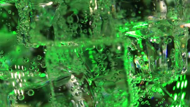 緑色の発泡ソーダで泡立つ氷の立方体をクローズアップ — ストック動画