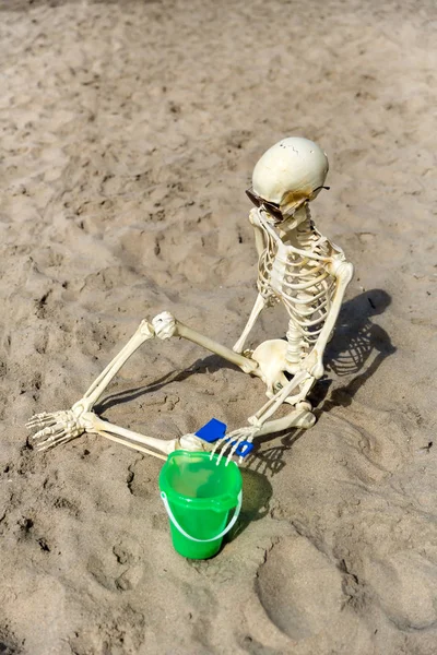 Скелет Сидит Пляже Играя Песке Ведром Лопатой — стоковое фото