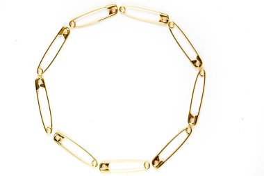 Beyaz arka plan üzerinde emniyet pimlerinden yapılmış daire şekli