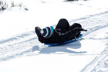 Çocuk sıcak kış giysileri içinde paketlenmiş bir kızak sürme