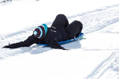 Çocuk sıcak kış giysileri içinde paketlenmiş bir kızak sürme