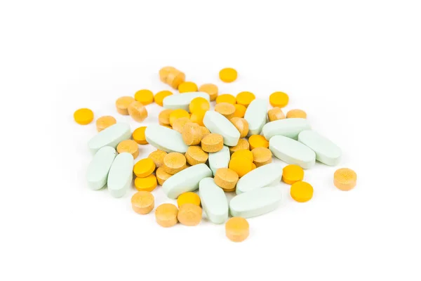 Διάσπαρτα Πράσινα Και Κίτρινα Χάπια Πάνω Από Ένα Λευκό Φόντο — Φωτογραφία Αρχείου