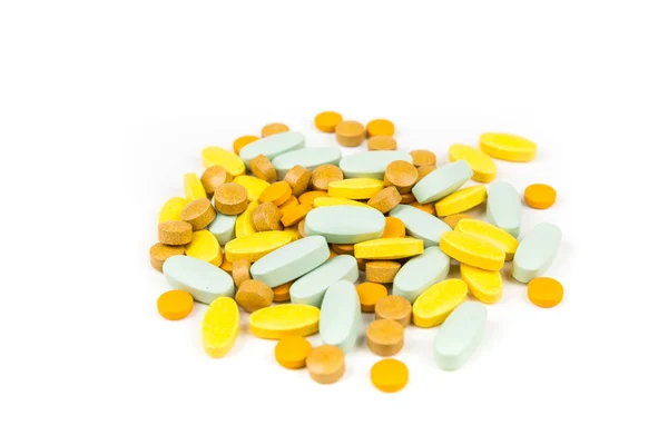 白い背景の上に緑のオレンジと黄色の錠剤の山 — ストック写真