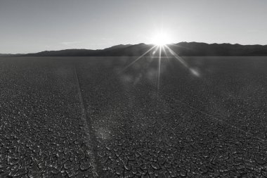 Gün batımında çölden dağlara çatlamış playa çamur dokusu