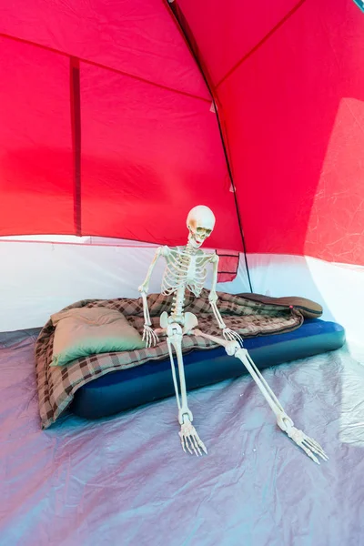 Kamp yaparken çadırda şiltede oturan iskelet