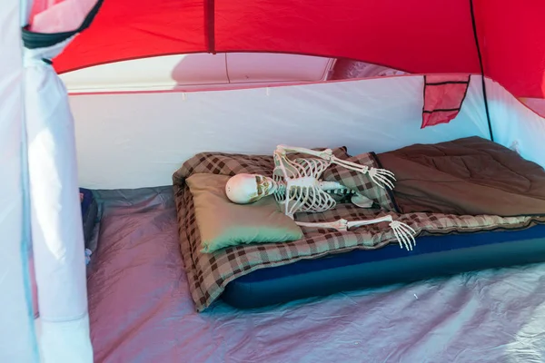 Skeleton relaxing in a tent while camping