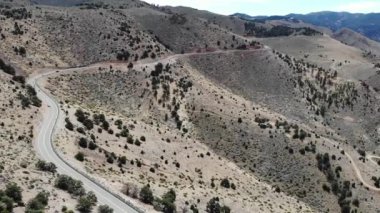 Çöldeki bir dağ yolunda trafik arabaları ve motosikletlerin üzerinde insansız hava aracı.