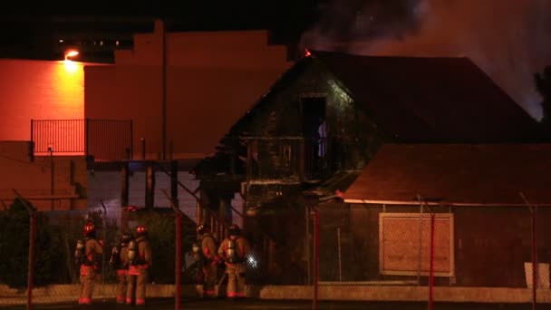 Strażacy Sprawdzający Spalone Nadal Palenie Ognia Domu Dachu Nocy Pożaru — Wideo stockowe