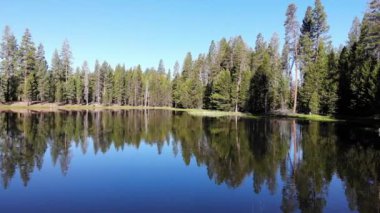 Derin mavi gölün kenarını takip edin. Gölge ve ışıkta yavaşça yüzen pelikanla karşılaşın.