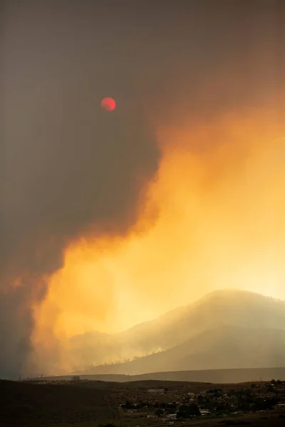 Mountain and valley landscape with wildfire smoke obscuring the sun