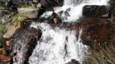  Suyun yavaş çekimde kahverengi kayalardan aşağı düşmesi rahatlatıcı bir şablon..