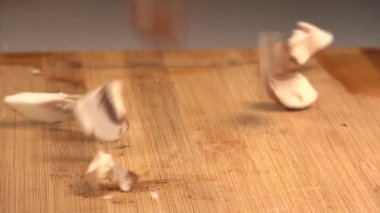 Kabaca dilimlenmiş parçalar ve mantar parçaları rastgele kesim tahtasına düştü.