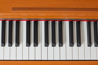 Ahşap bir kasada Işıkta Elektrikli Piyano Tuşları.