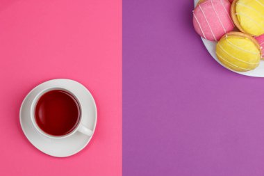 pembe mor bir arka plan üzerinde kırmızı ve sarı kurabiye bir fincan