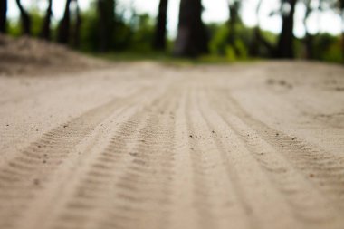 Kum lastik izleri görüntü kadar kapatın. Dokulu lastik üzerinde kum portre izler. Endüstriyel arka plan. Nervürlü diziniz tekerlek koruyucular.