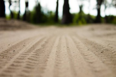 Kum lastik izleri görüntü kadar kapatın. Dokulu lastik üzerinde kum portre izler. Endüstriyel arka plan. Nervürlü diziniz tekerlek koruyucular.