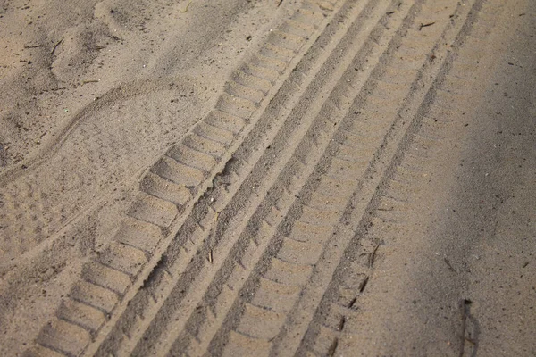 Kum lastik izleri görüntü kadar kapatın. Dokulu lastik üzerinde kum portre izler. Endüstriyel arka plan. Nervürlü diziniz tekerlek koruyucular.