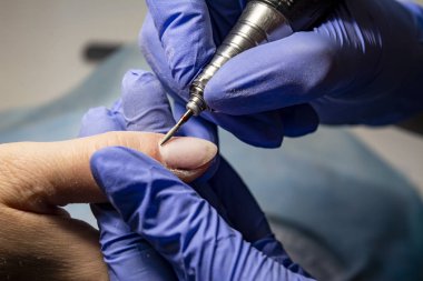 Tırnak servisi. Güzellik stüdyosunda kullanılan elektrikli tırnak dosyası matkap.