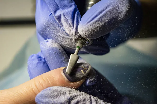 Tırnak servisi. Güzellik stüdyosunda kullanılan elektrikli tırnak dosyası matkap.