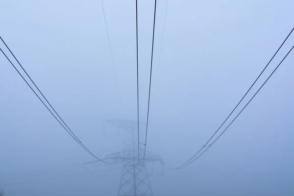 Elektrická podpora vysokonapěťových silových kabelů v husté mlze — Stock fotografie
