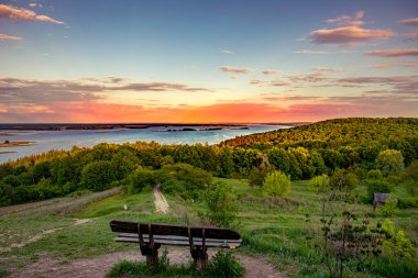 Nehre bakan güzel bir manzara. Ön planda bank