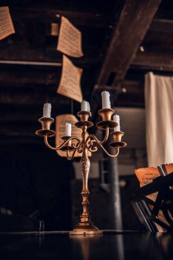 Sönmüş mumları, şamdanların üzerinde uçan müzik kağıtları olan güzel klasik metal şamdanlar..