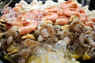  deniz ürünleri, karides, yumuşakçalar, mürekkep balığı, kalamar ve midye limon ile kokteyl ve buz parçaları.