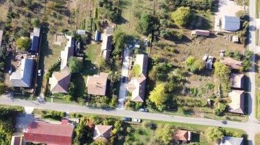 Tarlalar, tarlalar ve yeşilliklerle çevrili kırsal bir Macar köyünün manzarası. Dağınık evler, yollar ve insansız hava aracı tarafından yakalanan doğal güzelliklerle dolu huzurlu bir kırsal alan..