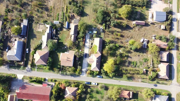 Tarlalar, tarlalar ve yeşilliklerle çevrili kırsal bir Macar köyünün manzarası. Dağınık evler, yollar ve insansız hava aracı tarafından yakalanan doğal güzelliklerle dolu huzurlu bir kırsal alan..