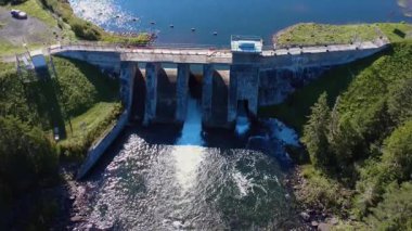 Aşağıdaki bir çukura taşan eski bir hidroelektrik barajın havadan görüntüsü hızla bir kuş tarafından uçuruldu. Mitis Barajı, Quebec, Kanada, 2025.