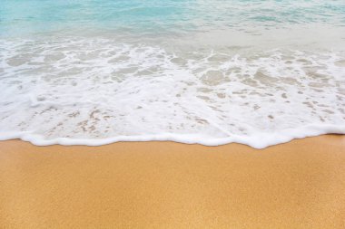 Kumlu sahilde yumuşak bir mavi okyanus dalgası. Arkaplan.
