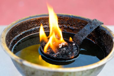 Bir pirinç yağı lambası tek yanan alev