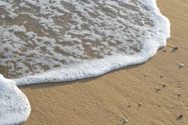 Kumlu sahilde yumuşak bir mavi okyanus dalgası. Arkaplan.