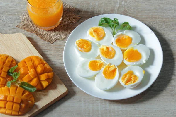 Kahvaltıda portakal suyu ve mango ile haşlanmış yumurta