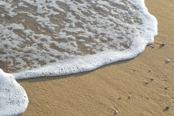 Kumlu sahilde yumuşak bir mavi okyanus dalgası. Arkaplan.