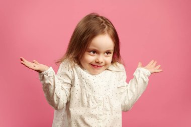 Şaşkın çocuk omuzlarını silkiyor ve eller yükseltir, cehalet ya da zorluk ifade eder, sorunun cevabını bilmiyor.