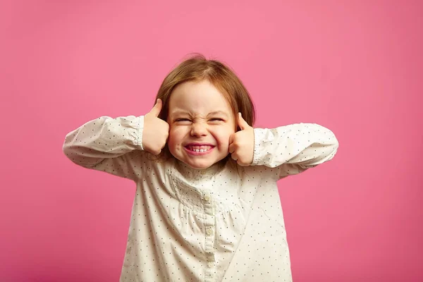 Смешной снимок маленькой девочки с поднятыми пальцами — стоковое фото