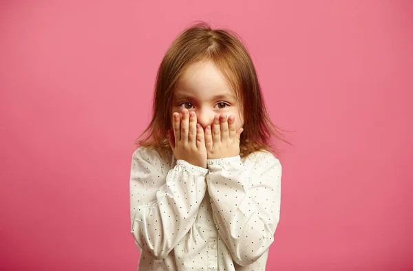 어린 소녀 커버 핑크 격리 된 배경에 손으로 그녀의 입. — 스톡 사진