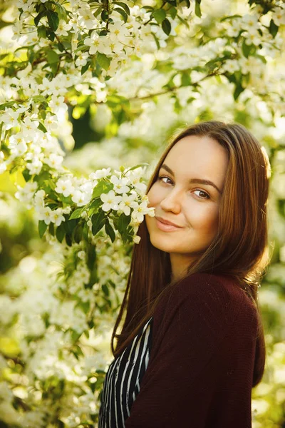 Mujer encantadora con una calle de árbol floreciente . — Foto de Stock