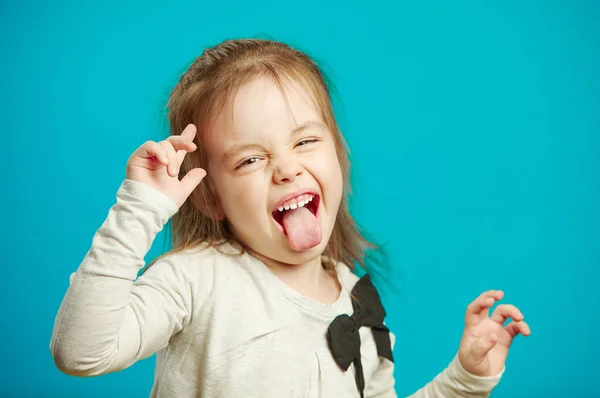 Enojada niña muestra su lengua en divertida mueca — Foto de Stock