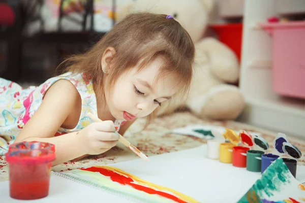 Niña se encuentra en el suelo del dormitorio y pintura cuadro — Foto de Stock