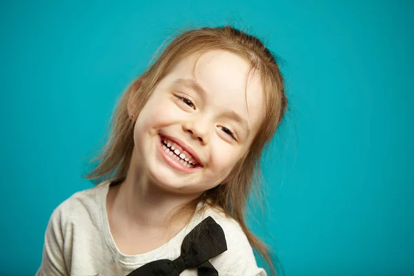 Słodka dziewczynka uśmiechając się na niebieskim tle na białym tle. — Zdjęcie stockowe