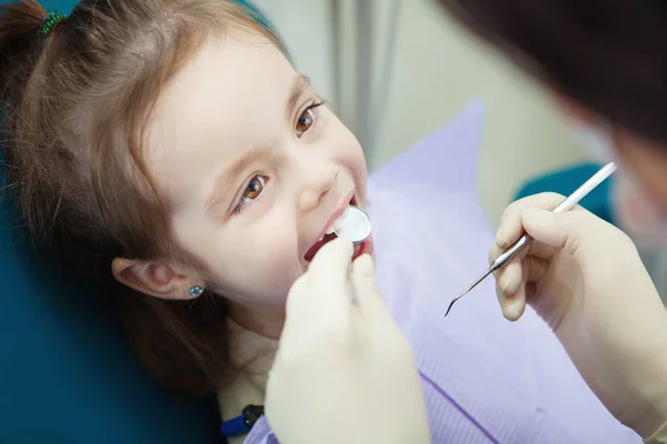 Criança feliz na cadeira do dentista com guardanapo no peito — Fotografia de Stock