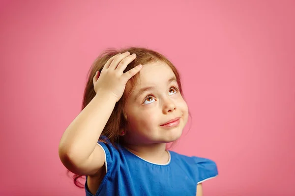 Nettes Kindermädchen legt die Hand an den Kopf und schaut auf — Stockfoto