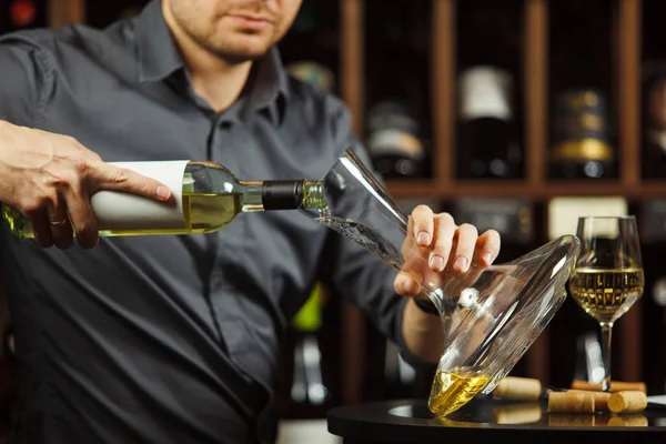 Primer plano de sommelier serio verter vino blanco en decantador — Foto de Stock