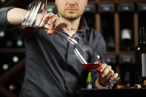 Сомельє наливає вино в склянку зі змішувальної чаші. Чоловічий офіціант — стокове фото
